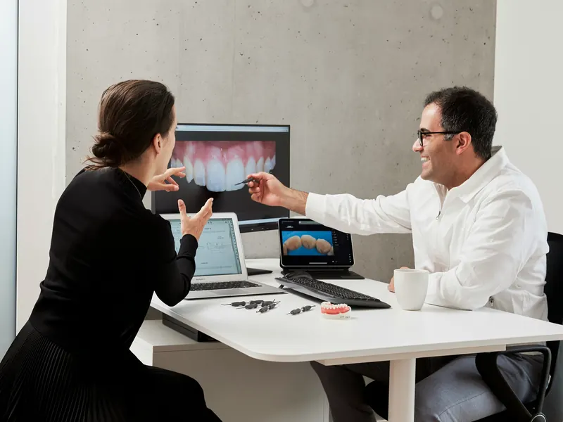 A dentist talks a patient through her smile plan on a screen